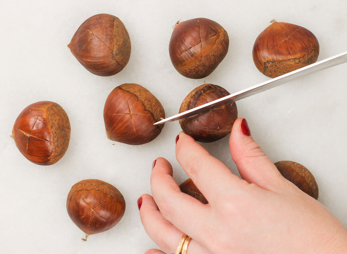 cutting an x into the top of each chestnut with a serrated knife