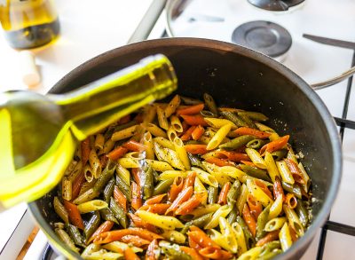 adding white wine in a skillet with homemade pasta