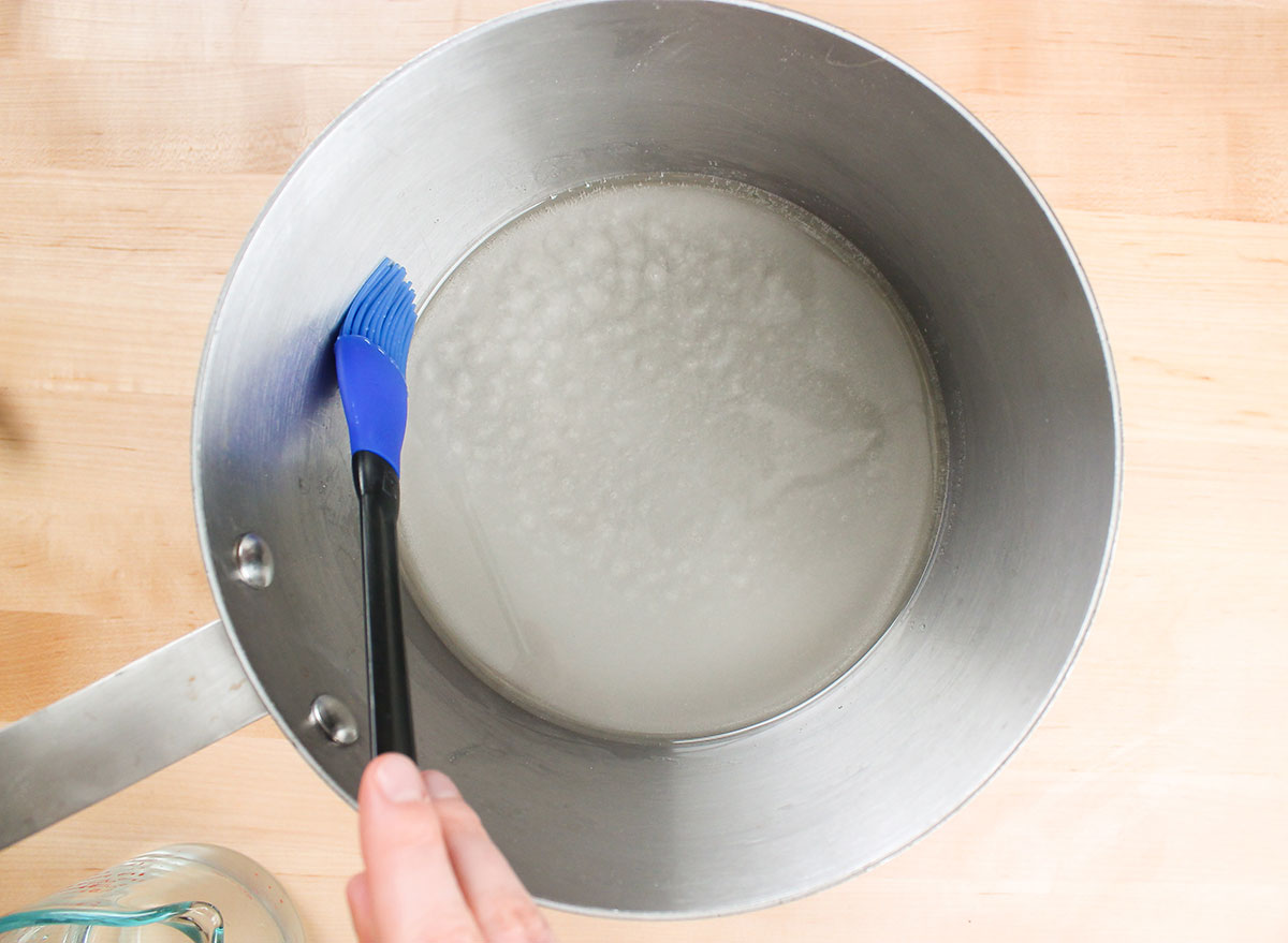 brushing water on side of pot while making caramel