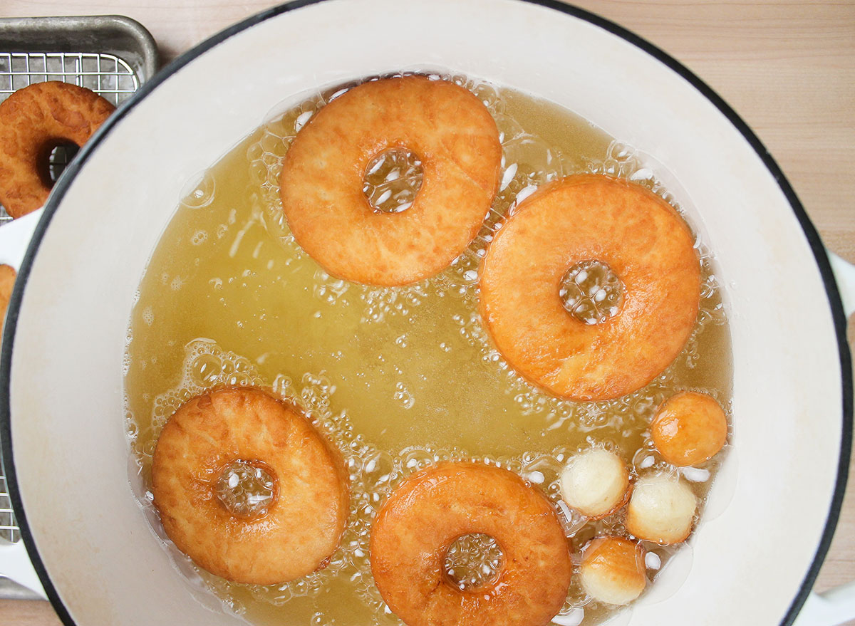 flipped donuts frying in a dutch oven