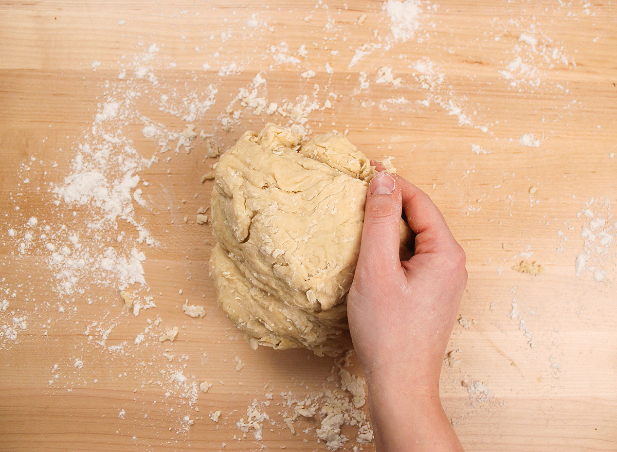 kneading donut dough on a floured surface