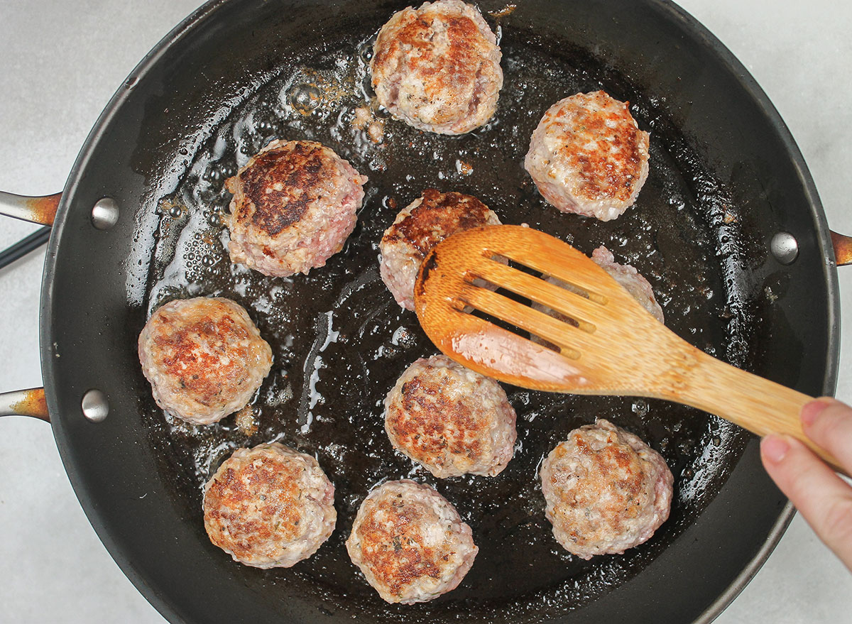 pan searing meatballs on a skillet