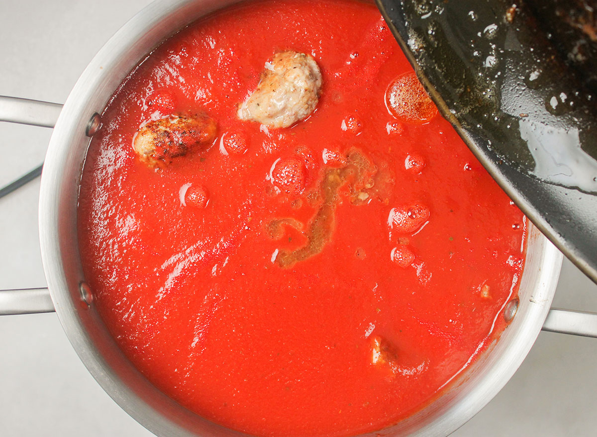 adding grease to pot of meatballs and sauce