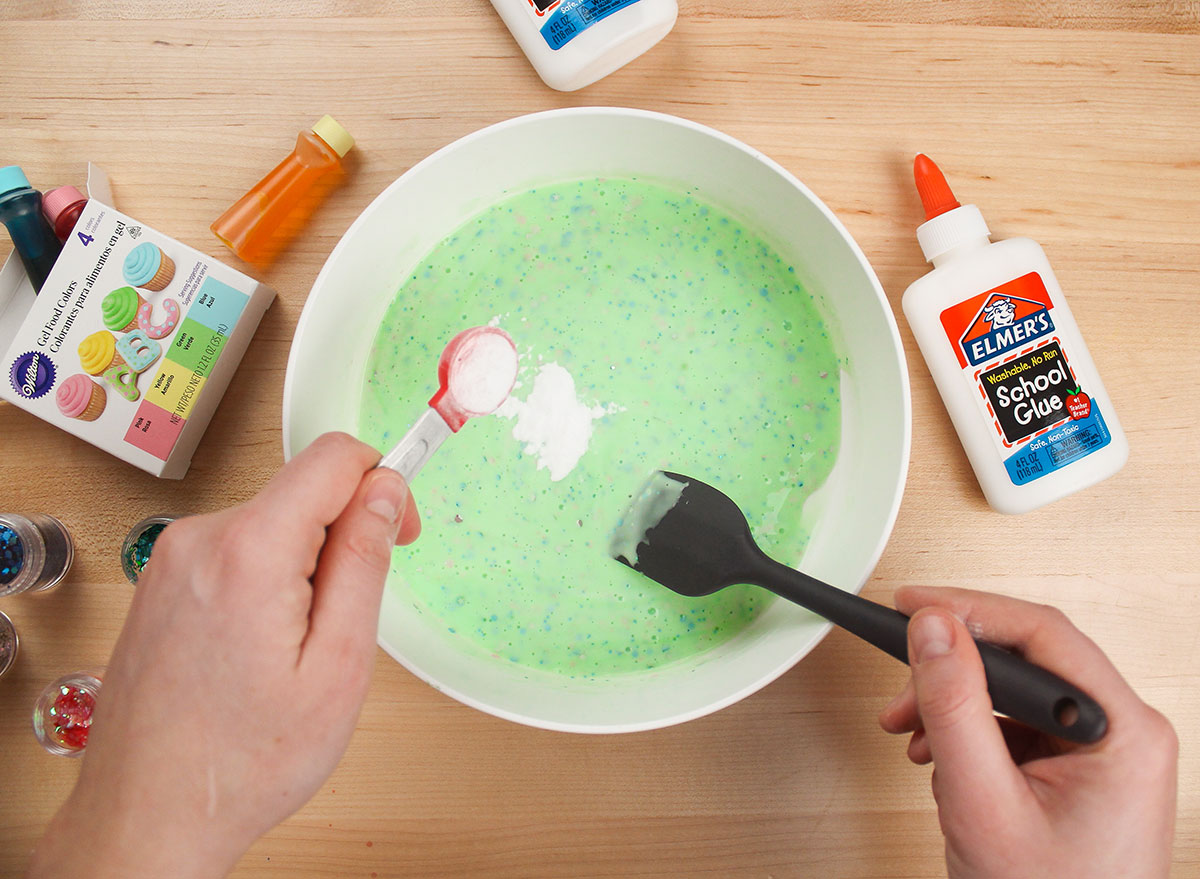 adding baking soda to slime mixture in a bowl