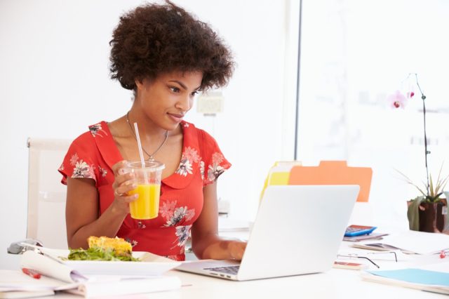 Woman Working In Design Studio Having Lunch At Desk