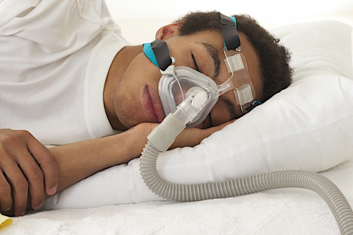 man sleeping with apnea and CPAP machine