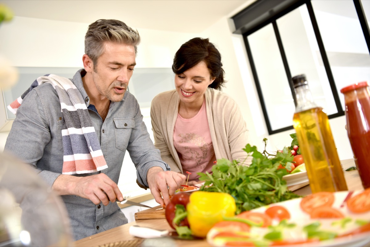 Middle-aged couple having fun cooking together