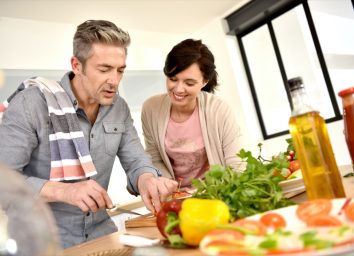 Middle-aged couple having fun cooking together