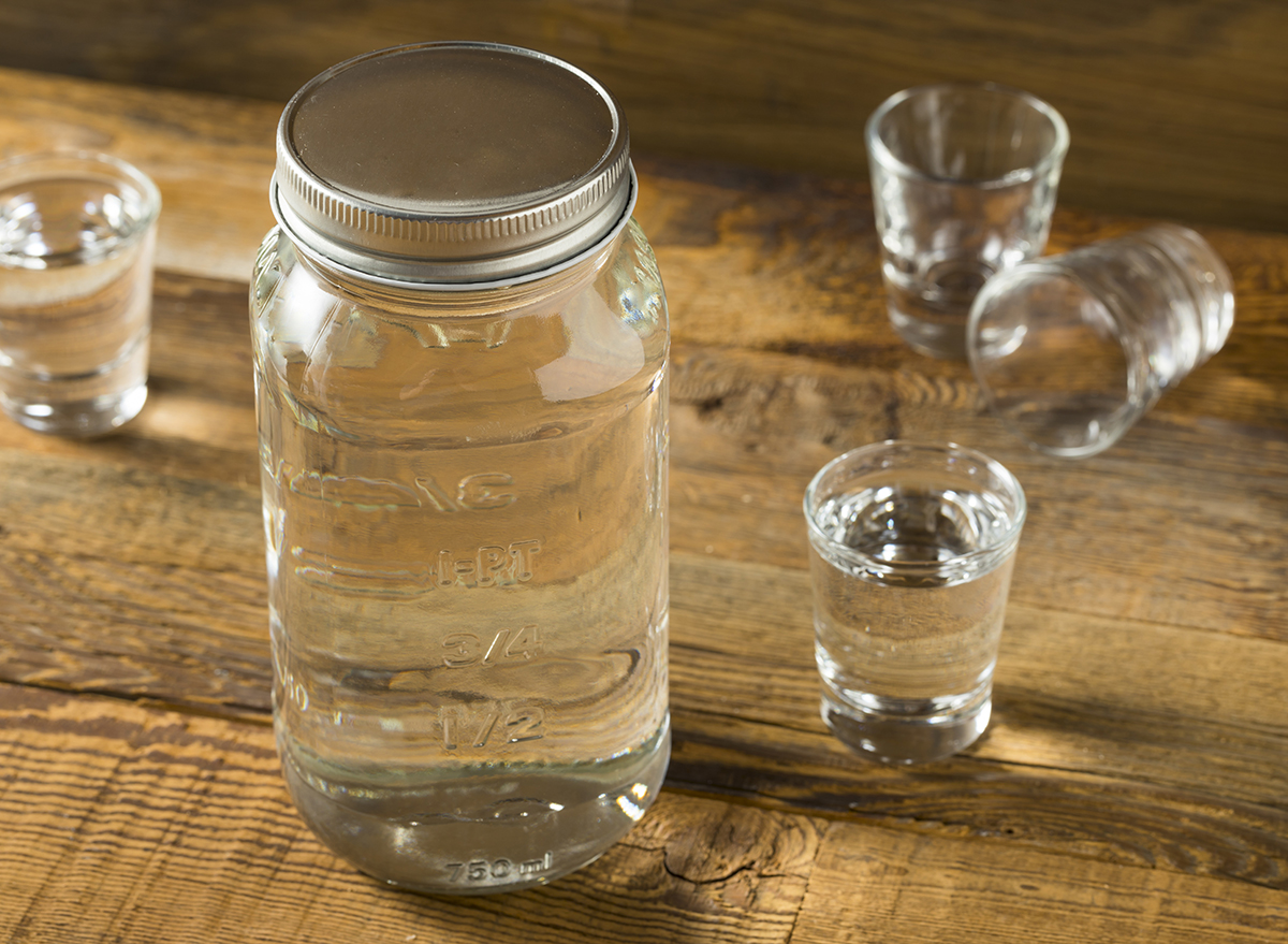mason jar and shot glasses of moonshine