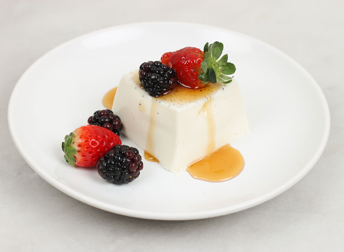 panna cotta with fresh berries and syrup on a plate