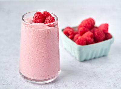 raspberry cashew butter cottage cheese smoothie garnished with raspberries