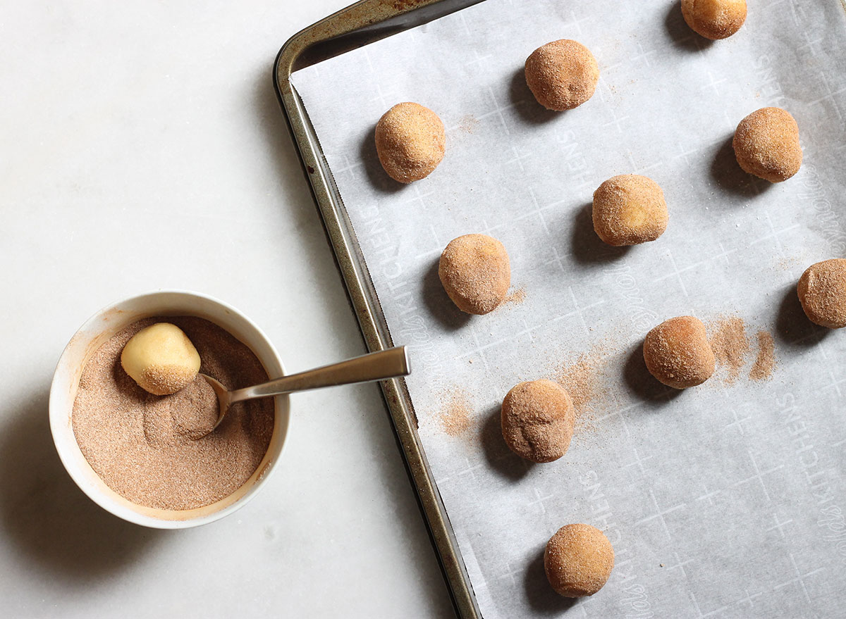 rolling snickerdoodle cookie dough into cinnamon sugar