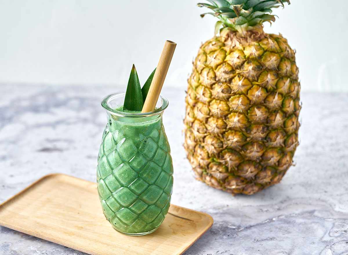 spirulina pina colada smoothie with pineapple in background