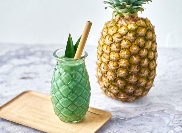 spirulina pina colada smoothie with pineapple in background