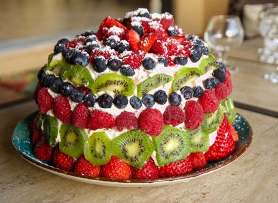 sponge cake topped with raspberries blueberries and kiwi