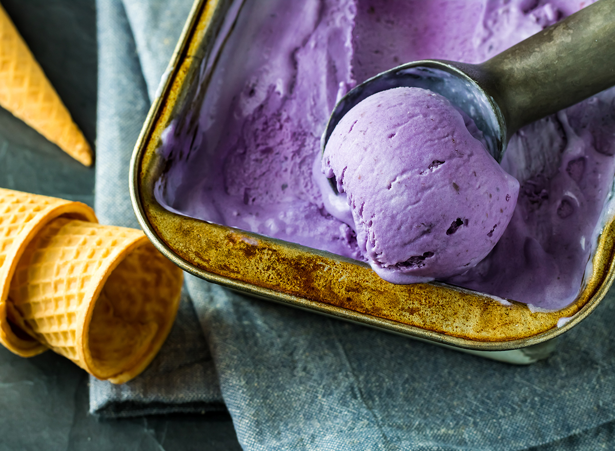 tub of ube ice cream with scoop and cones