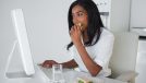 businesswoman eating a sandwich at her desk in her office
