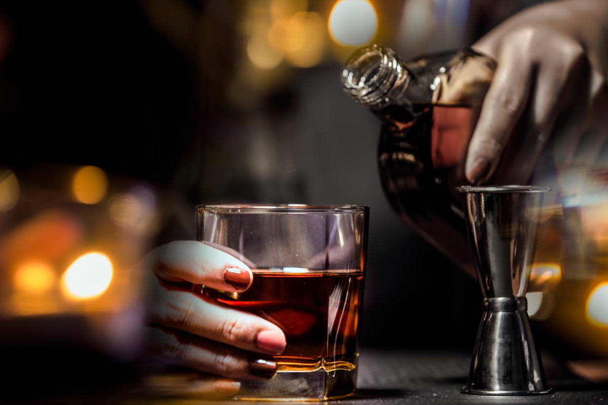 Bartender Serve Whiskey, on wood bar.