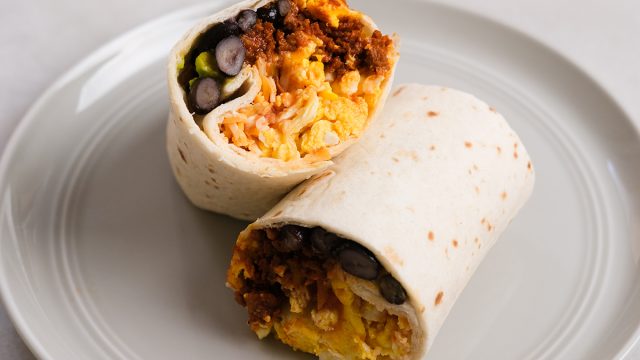breakfast burrito cut in half on a plate ready to eat