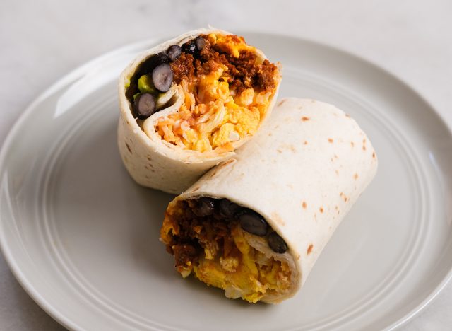Breakfast burrito cut in half on a ready-to-eat plate