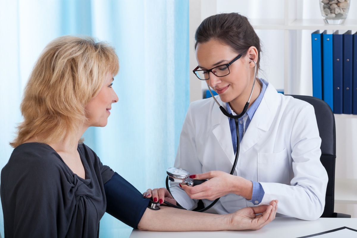 female doctor taking blood pressure.