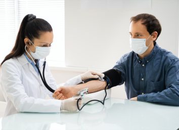 Doctor Checking High Blood Pressure In Face Mask