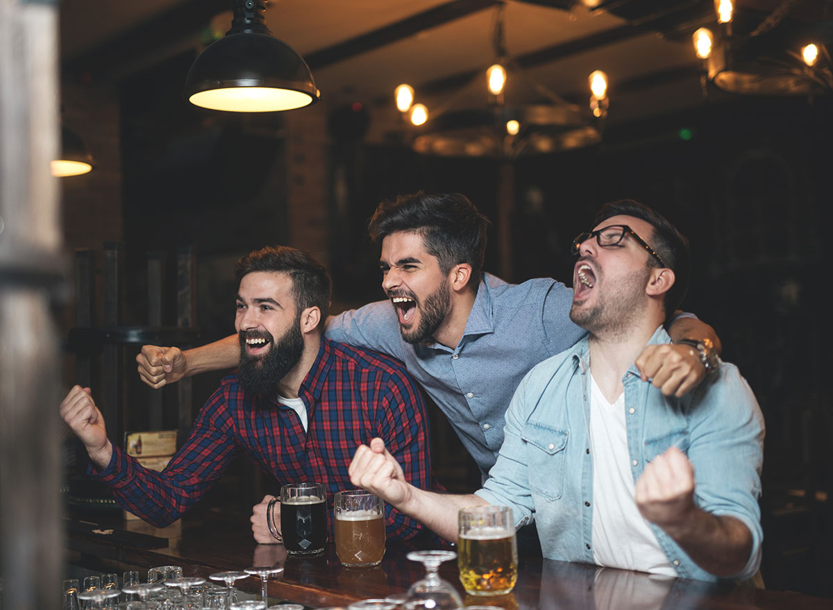 football fans watching the game and drinking beer at a bar