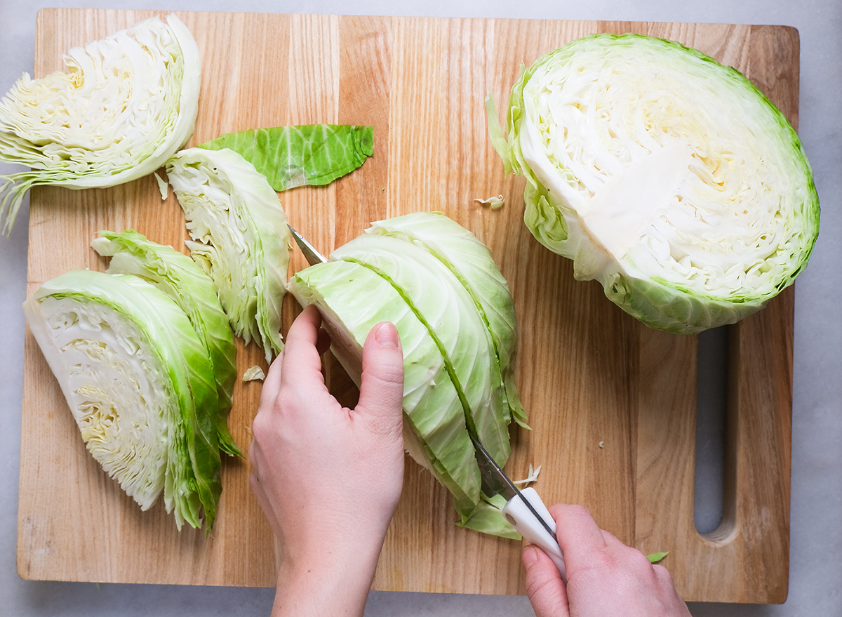 slicing a cabbage into wedges on a cutting board