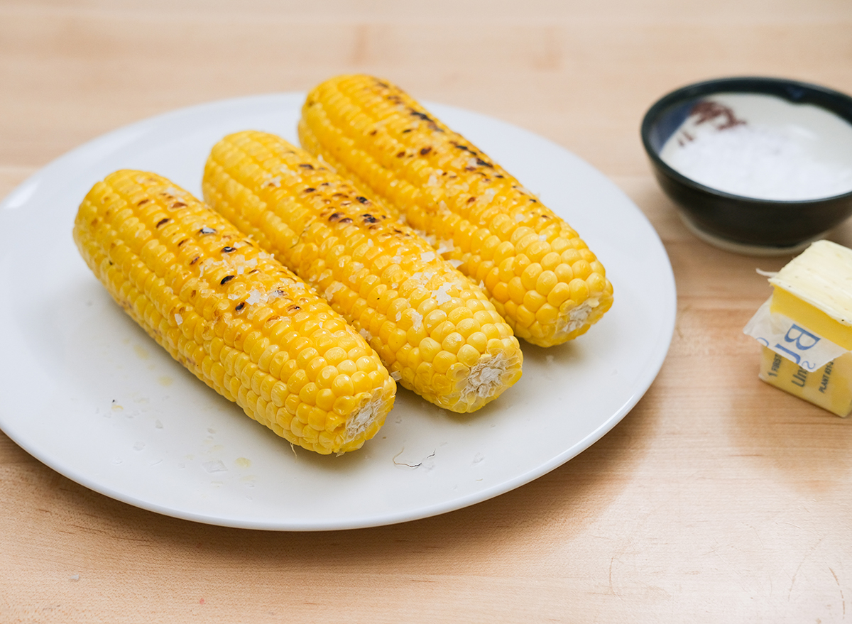 cooked corn with salt and butter on a plate