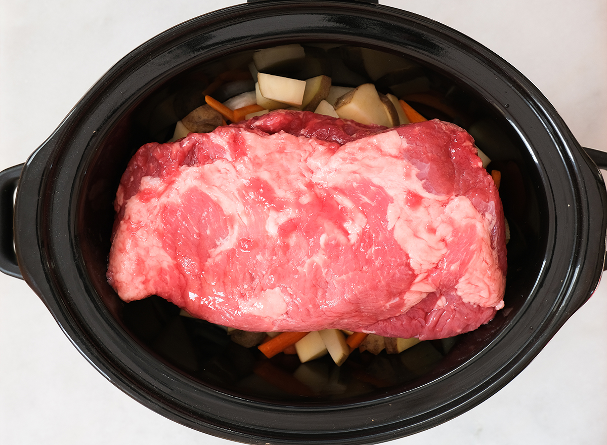 uncooked corned beef in a slow cooker