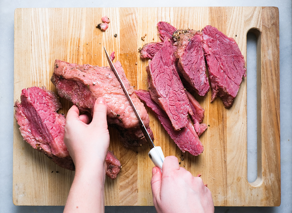 slicing corned beef on a cutting board