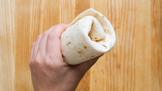 holding a folded burrito
