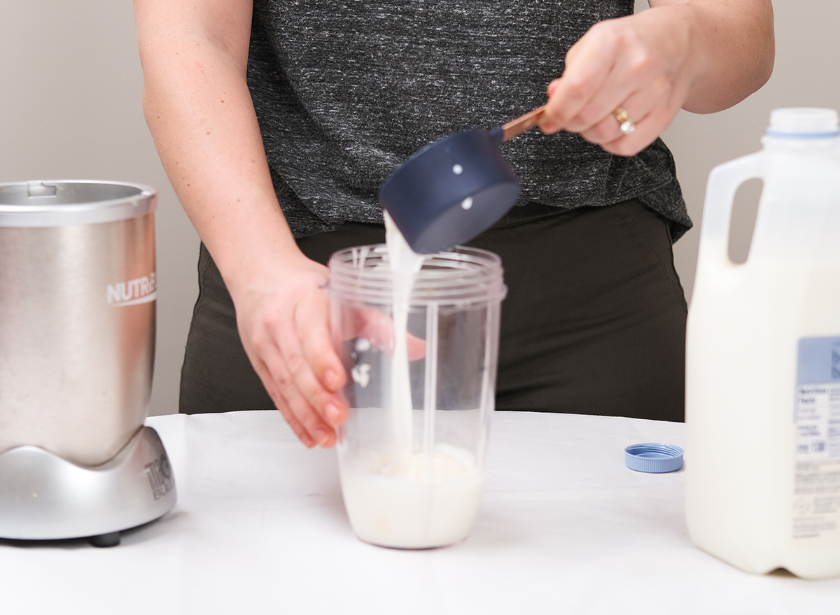 pouring milk into a blender with ice cream