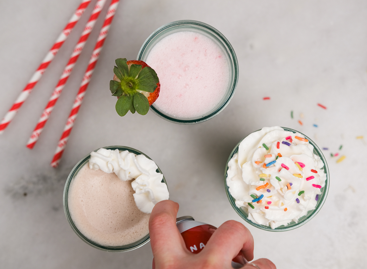 adding whipped cream to a milkshake