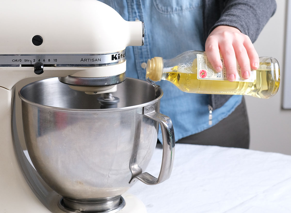 slowly pouring oil into a stand mixer