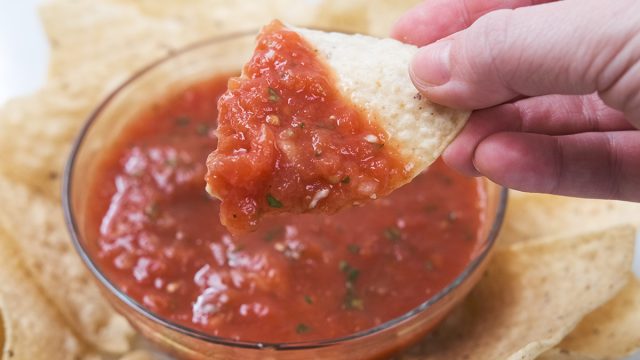 dipping into salsa with a tortilla chip