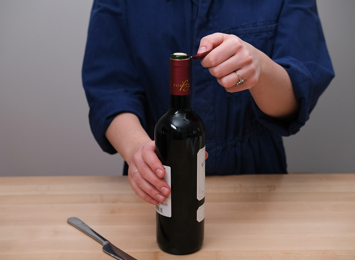 opening up the wrapper for a bottle of wine