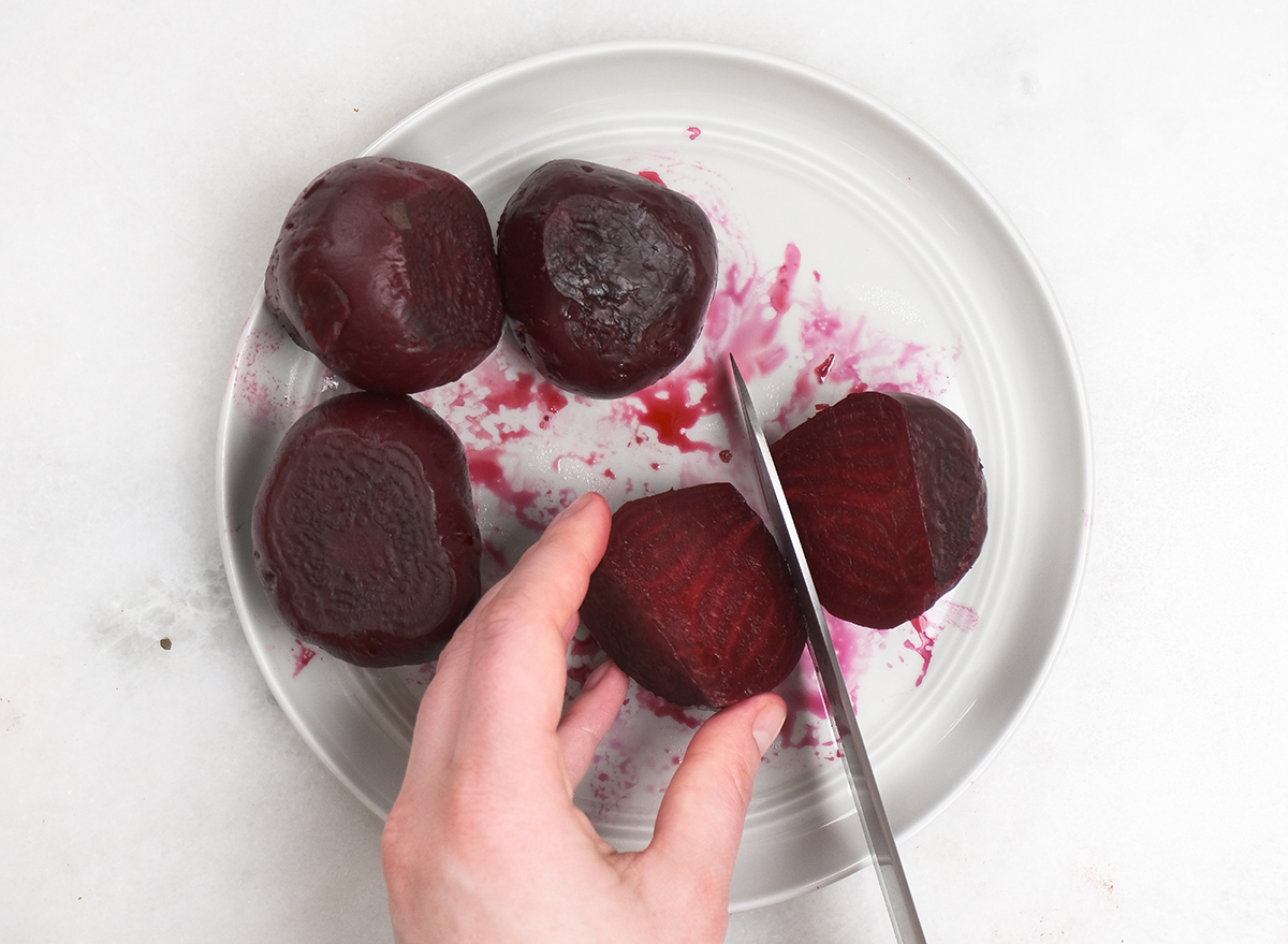 slicing open roasted beets on a plate