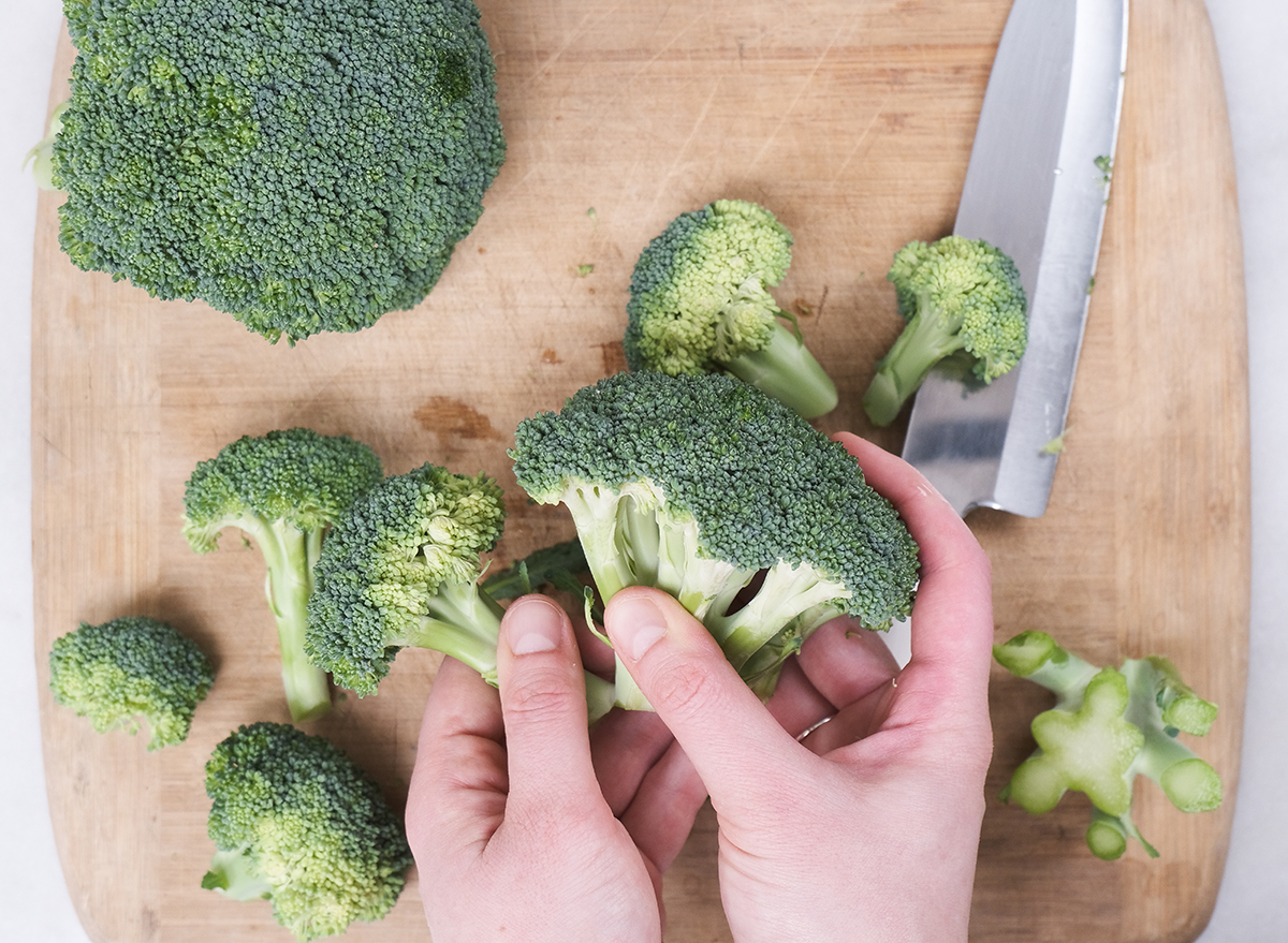 tearing apart broccoli florets from a crown