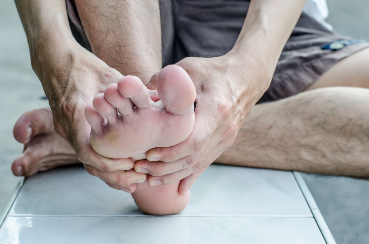 Man's hand being massaged a foot