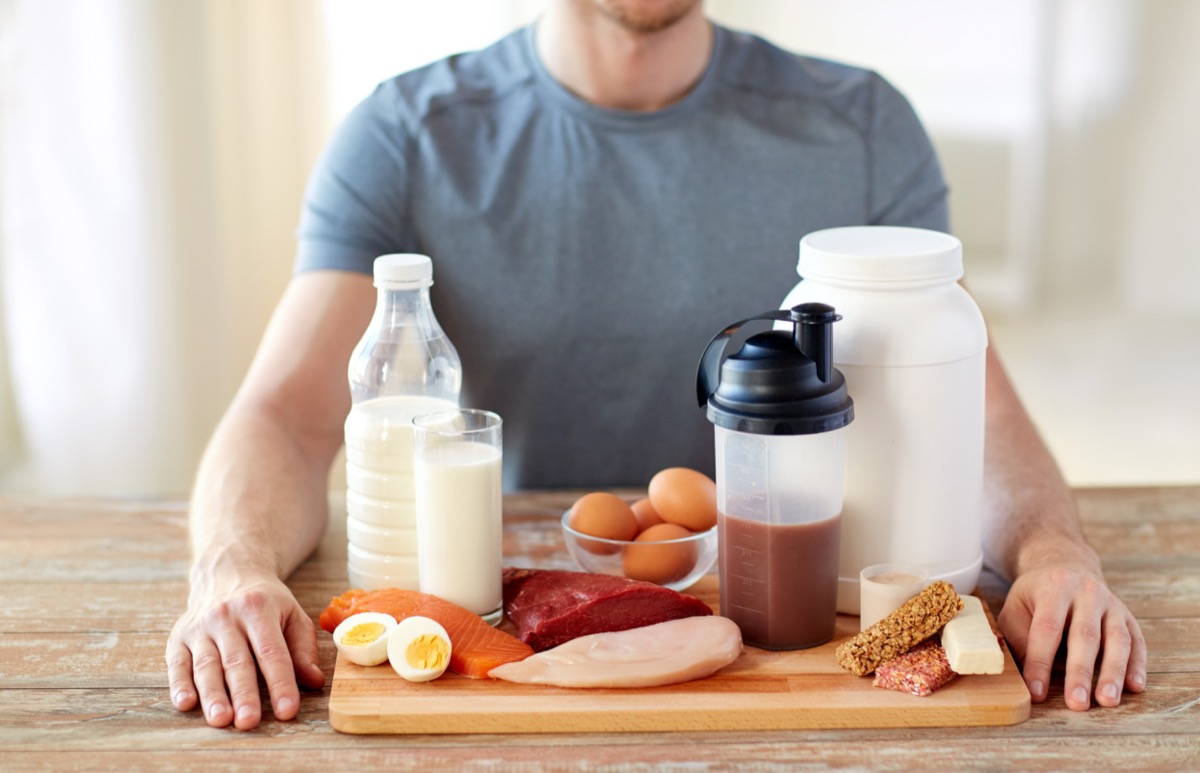 Man sitting in front of various protein foods at a table