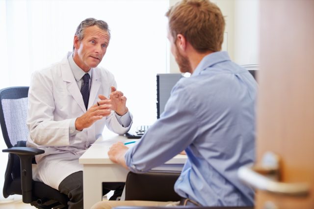 A male patient is consulting a doctor in the office