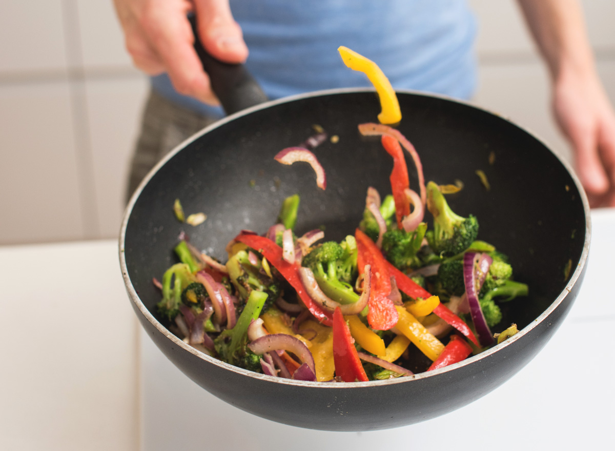 Many stir frying in a wok