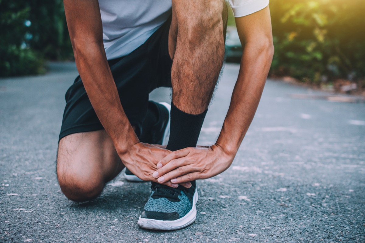 Runner injured in the foot while jogging space patella sore on road, jogger hands joint leg problem injury massage runner strain, athlete ache sport healthy