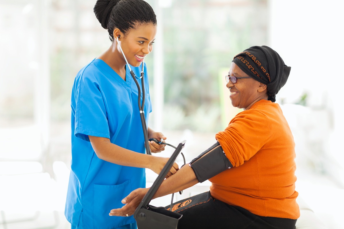 nurse checking woman's blood pressure