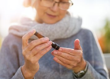 Woman checking blood sugar level while sitting on bench