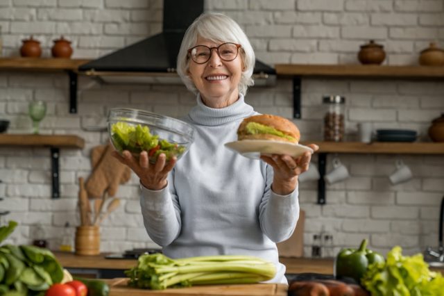 An elderly woman chooses between healthy and unhealthy food