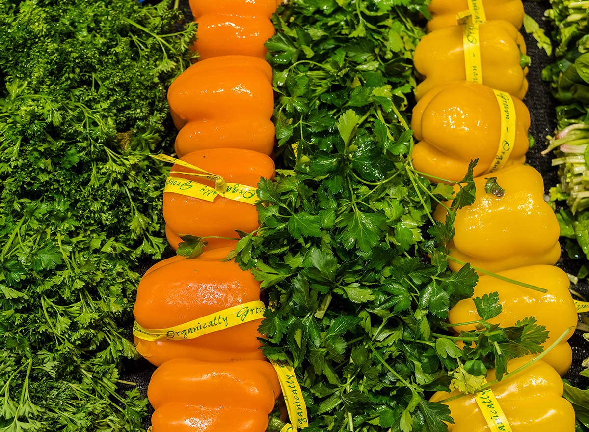 organic orange and yellow bell peppers in grocery store