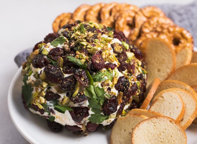 close up of pistachio cranberry cheese ball on a plate