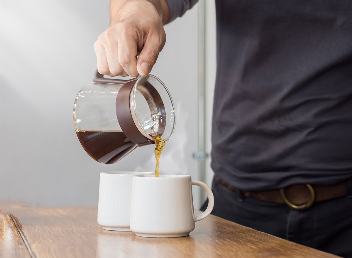 coffee pot pouring into two mugs